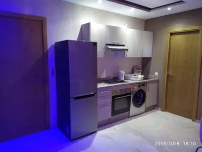 a kitchen with a refrigerator and a washing machine at Superbe appartement Hivernage in Marrakech
