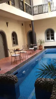 a swimming pool with chairs and a table next to a house at 