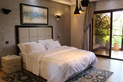 a bedroom with a large white bed and a window at Magnifique villa avec piscine chauffée que pour famille in Marrakech