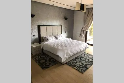 a bedroom with a white bed and a window at Magnifique villa avec piscine chauffée que pour famille in Marrakech
