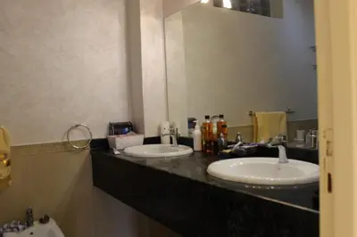 a bathroom with two sinks and a large mirror at Magnifique villa avec piscine chauffée que pour famille in Marrakech