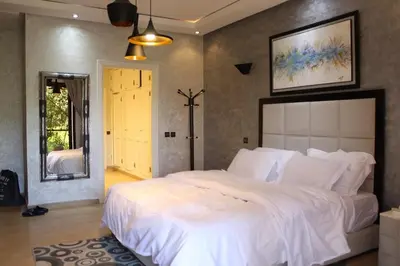 a bedroom with a large white bed in a room at Magnifique villa avec piscine chauffée que pour famille in Marrakech
