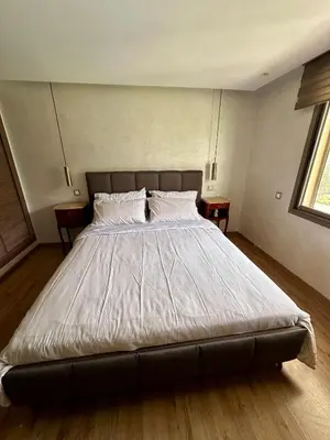 a large bed in a bedroom with two tables at Cosy Duplex, dans résidence avec piscine in Marrakech