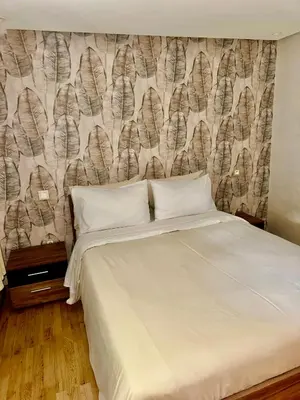 a bedroom with a bed and a wall with feathers at Cosy Duplex, dans résidence avec piscine in Marrakech
