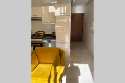 a kitchen with a yellow chair in a kitchen at Cosy Duplex, dans résidence avec piscine in Marrakech