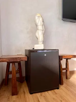a statue sitting on top of a refrigerator next to two tables at Cosy Duplex, dans résidence avec piscine in Marrakech