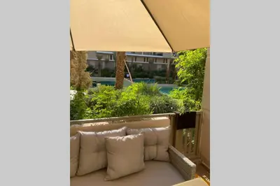a couch with pillows sitting on a balcony at Cosy Duplex, dans résidence avec piscine in Marrakech