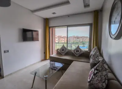 a living room with a couch and a large window at Prestigia Golf City Marrakech in Marrakech
