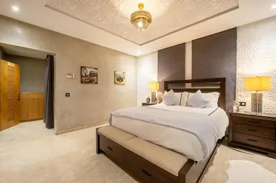 a large bedroom with a large bed and a chandelier at Villa Dar Laila in Marrakech