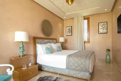 a bedroom with a bed and a table with a lamp at Villa Dar Laila in Marrakech