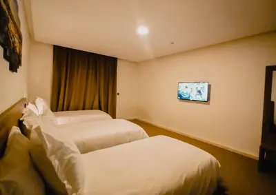 a hotel room with two beds and a tv at EL MOUSSAFIR HOTEL in Marrakech