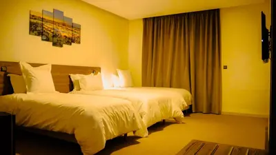 a hotel room with two beds and a window at EL MOUSSAFIR HOTEL in Marrakech
