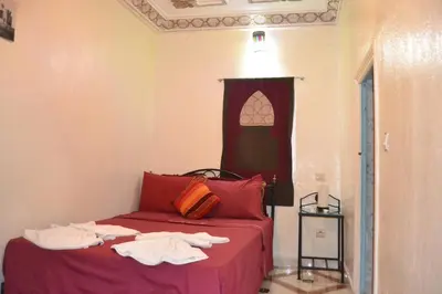 a bedroom with a red bed with towels on it at Riad el Boukhiri in Marrakech