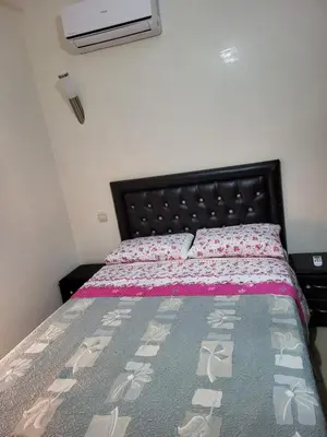 a bedroom with a bed with a pink and gray bedspread at 90 qm Wohnung mit 2 Schlafzimmern in Marrakech