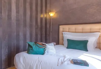 a bedroom with a bed with green and white pillows at dar al walidine in Marrakech