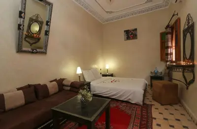 a living room with a couch and a bed at Riad Maissoun in Marrakech