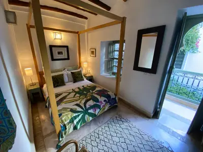 a bedroom with a canopy bed and a large window at Riad Timila in Marrakech