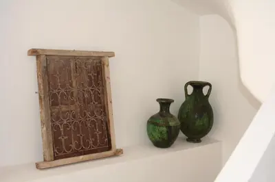 two vases sitting on a shelf next to a plaque at Riad Timila in Marrakech