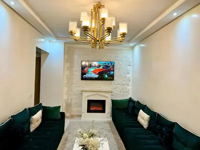 a living room with a green couch and a fireplace at Duplex Sabah Opera - Quartier Hivernage in Marrakech