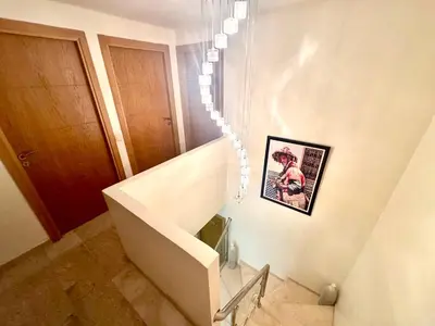 a white staircase with a picture on the wall at Duplex Sabah Opera - Quartier Hivernage in Marrakech
