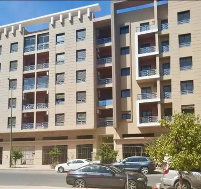 a large apartment building with cars parked in front of it at Duplex Sabah Opera - Quartier Hivernage in Marrakech