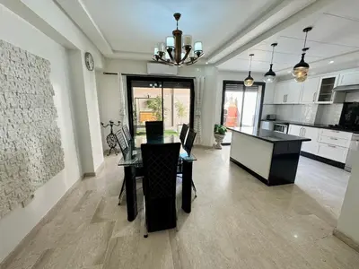 a dining room and kitchen with a table and chairs at Duplex Sabah Opera - Quartier Hivernage in Marrakech
