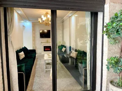 a living room with a green couch and a fireplace at Duplex Sabah Opera - Quartier Hivernage in Marrakech