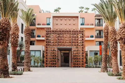 a building with palm trees in front of it at Pestana CR7 Marrakech in Marrakech