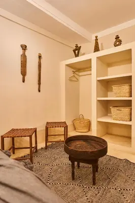 a living room with a table and two stools at Riad Algora en exclusivité 13 P au cœur de la Médina in Marrakech