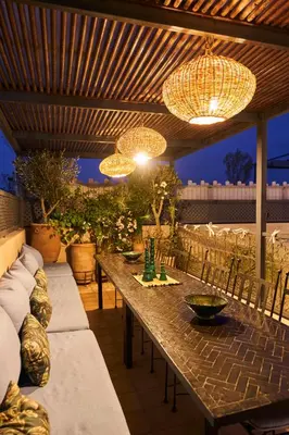 a patio with a long wooden table and chandeliers at Riad Algora en exclusivité 13 P au cœur de la Médina in Marrakech