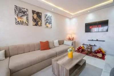 a living room with a couch and a table at LUXURY APARTMENT IN THE HEART OF MARRAKECH GUELIZ in Marrakech