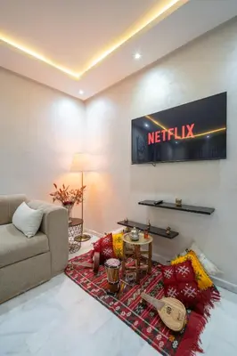 a living room with a couch and a television at LUXURY APARTMENT IN THE HEART OF MARRAKECH GUELIZ in Marrakech