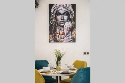 a dining room with a painting on the wall at LUXURY APARTMENT IN THE HEART OF MARRAKECH GUELIZ in Marrakech