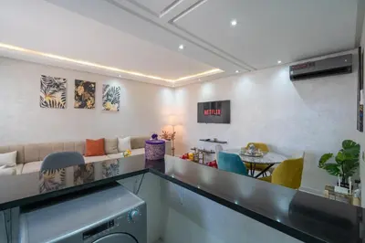 a living room with a couch and a table at LUXURY APARTMENT IN THE HEART OF MARRAKECH GUELIZ in Marrakech