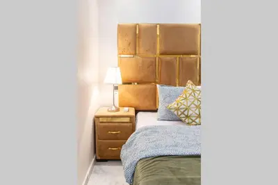 a bedroom with a bed with a large headboard at LUXURY APARTMENT IN THE HEART OF MARRAKECH GUELIZ in Marrakech
