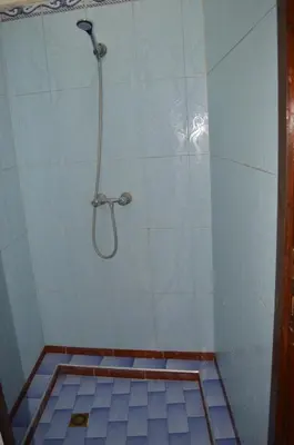 a bathroom with a shower with a tile floor at Hotel salem leksor in Marrakech
