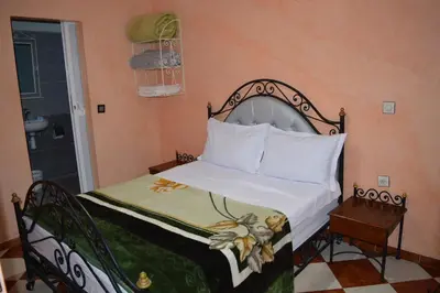 a bedroom with a bed with a white bedspread at Hotel salem leksor in Marrakech
