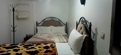 a bedroom with a bed with a black and white comforter at Hotel salem leksor in Marrakech