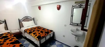 a room with a bed and a sink and a mirror at Hotel salem leksor in Marrakech