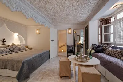 a bedroom with a bed and a couch and a table at Riad Star by Marrakech Riad in Marrakech