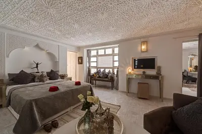 a bedroom with a bed and a living room at Riad Star by Marrakech Riad in Marrakech