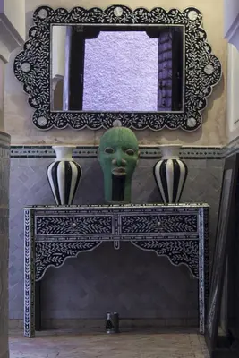 a mirror and a green head on top of a fireplace at Riad Dar Habiba by Garden Wonders in Marrakech