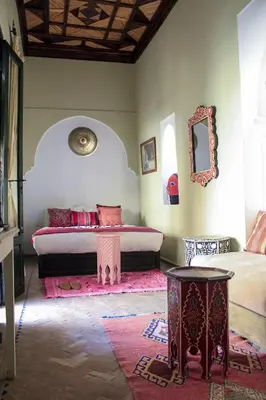 a bedroom with two beds and a mirror and a table at Riad Dar Habiba by Garden Wonders in Marrakech