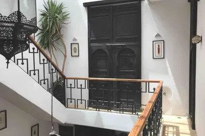a staircase with a black door and a black railing at Riad Touareg in Marrakech