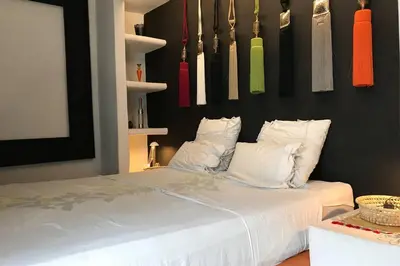 a bedroom with a bed with white pillows and hanging utensils at Riad Touareg in Marrakech