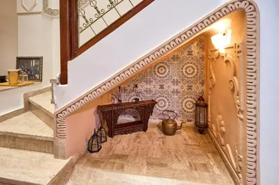 a hallway with a staircase with a tile wall at Riad AMBER ZAHRA in Marrakech