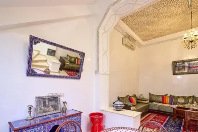a living room with a couch and a mirror on the wall at Riad AMBER ZAHRA in Marrakech
