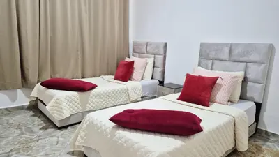 a room with two beds with red pillows on them at Le clos des oliviers de Marrakech in Marrakech