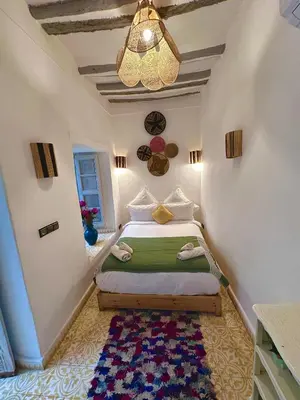 a bedroom with a bed and a chandelier at Riad Green Palm in Marrakech