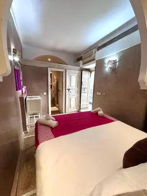 a bedroom with a large bed with a red blanket at Riad Green Palm in Marrakech